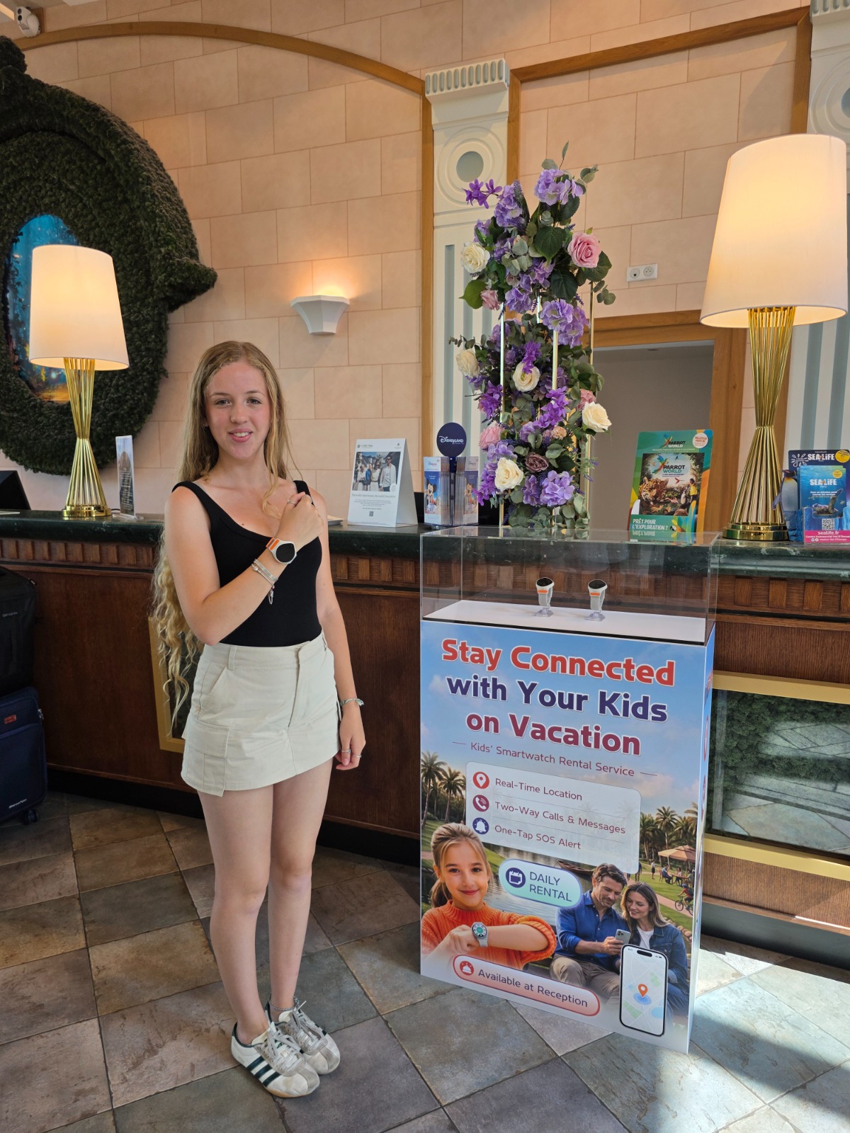A young hotel guest checks her rented KidiLink watch